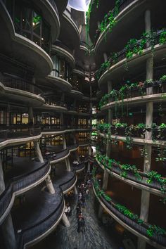 the interior of a large building with many balconies and plants growing on it