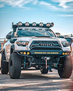 a white toyota truck with four lights on it