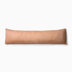 a tan pillow sitting on top of a white wall