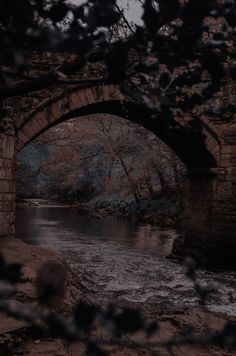 an old stone bridge over a small river