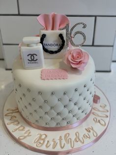 a birthday cake decorated with chandelier, perfume bottle and pink rose on top