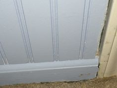 the corner of a door that has been stripped off and is white with some paint on it