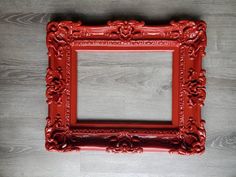 a red frame sitting on top of a wooden floor