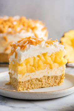 a piece of pineapple coconut cream pie on a plate with another slice in the background