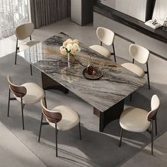 a dining table with white chairs around it