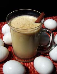 a glass mug filled with liquid surrounded by white eggs