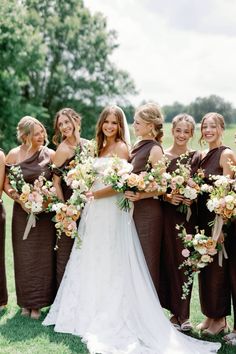 a group of women standing next to each other holding bouquets