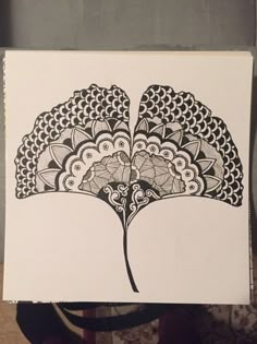 an intricately designed piece of art on a white paper with black ink in the middle