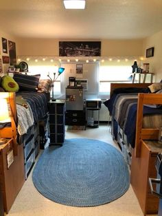 a dorm room with bunk beds, desks and other items on the floor in it