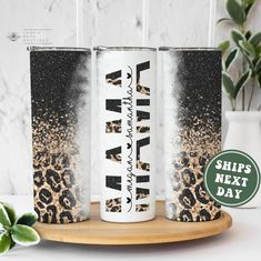 three personalized tumbles with leopard print and glitter on the sides, sitting on a plate