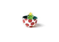 a small ceramic pot with a christmas tree in the center and polka dots on it