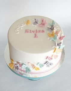 a white cake decorated with butterflies and the word blyba on it's side