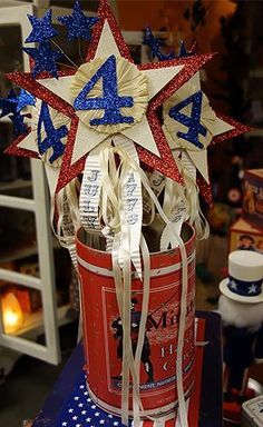 red, white and blue stars are in a bucket on top of a table next to other items