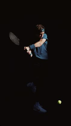 a man hitting a tennis ball with a racquet on a black background in the dark