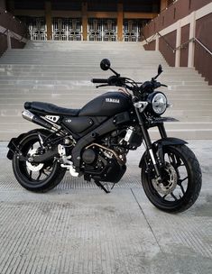 a black motorcycle parked in front of some steps