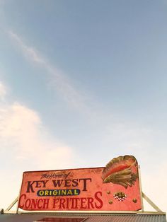 a large sign on the side of a building that says key west original conch fritters