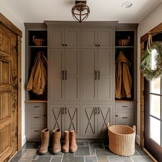 a mud room with wooden cabinets and shoes on the floor