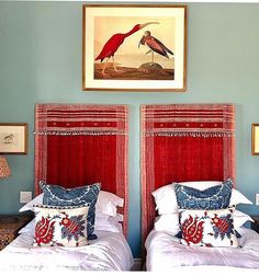 two beds with red headboards and blue walls