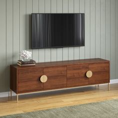 a large flat screen tv mounted to the side of a wooden cabinet in a living room