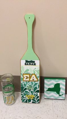 a green spatula sitting on top of a counter next to a jar of paint