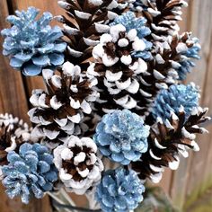 some blue and white pine cones are in a vase