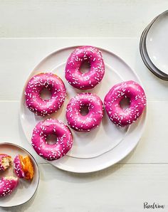 pink glazed donuts with sprinkles on a white plate