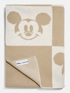 the mickey mouse blanket is on display in front of a white and brown checkered background