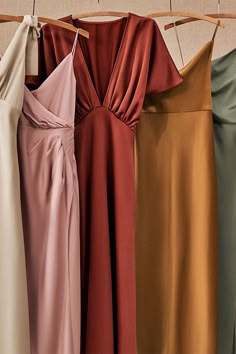 four different colored dresses hanging on a clothes line with one woman's dress in the foreground