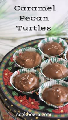 chocolate caramel pecan turtles in paper cups on a colorful plate with christmas decorations