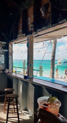 an empty bar overlooking the ocean with people on it