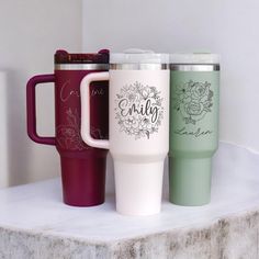 three different colored coffee mugs sitting next to each other on top of a counter