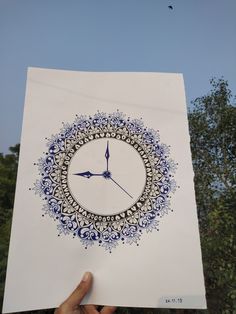 a person holding up a piece of paper with a clock drawn on it