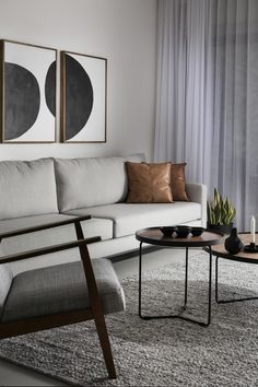 a living room with two paintings on the wall and a coffee table in front of it