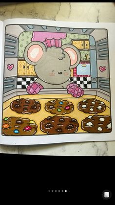 an open book with a mouse on top of it and cookies in front of it