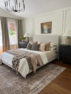 a large bed sitting in the middle of a bedroom next to two lamps on either side of it