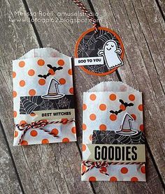 two bags with halloween tags on them sitting on a wooden table next to each other