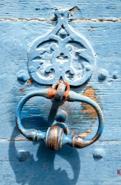 an old blue door handle on a wooden door