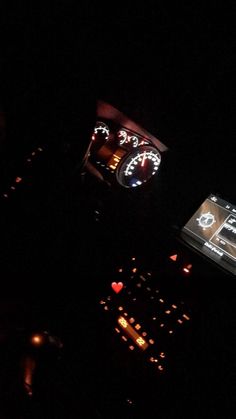 the dashboard of a car is lit up in the dark at night with lights on