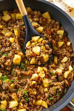 a skillet filled with meat and potatoes