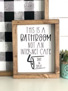 this is a bathroom not an internet cafe sign and potted plant next to it