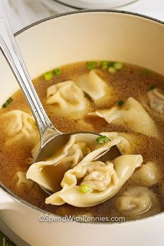 a ladle full of soup with dumplings in it