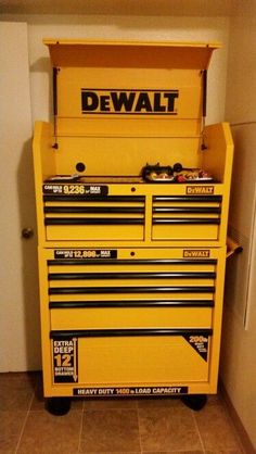 a yellow tool box sitting on top of a tile floor