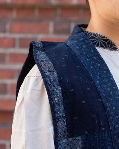 a man wearing a blue vest and white shirt