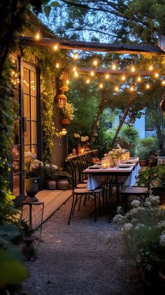 an outdoor dining area is lit up with string lights