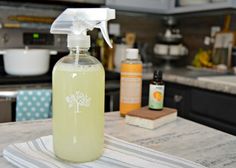 a bottle of liquid sitting on top of a kitchen counter next to a dish towel