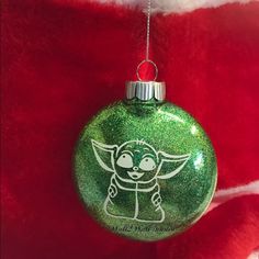 a green ornament with an image of a baby yoda on it