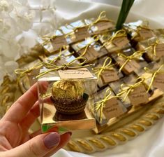 a person holding up a small box with a chocolate cupcake in it on a table