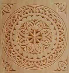 an intricately carved design on the side of a building's exterior, with leaves and flowers in the center