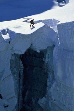 a man climbing up the side of a snow covered mountain