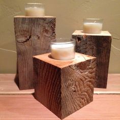 three wooden candlesticks with one candle in the middle and two on each side